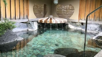 Una piscina nítida amb pedres, una cadira de fusta i una paret amb forma de cor.