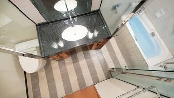 A modern bathroom with two sinks, a glass shower enclosure, and a checkered floor pattern.