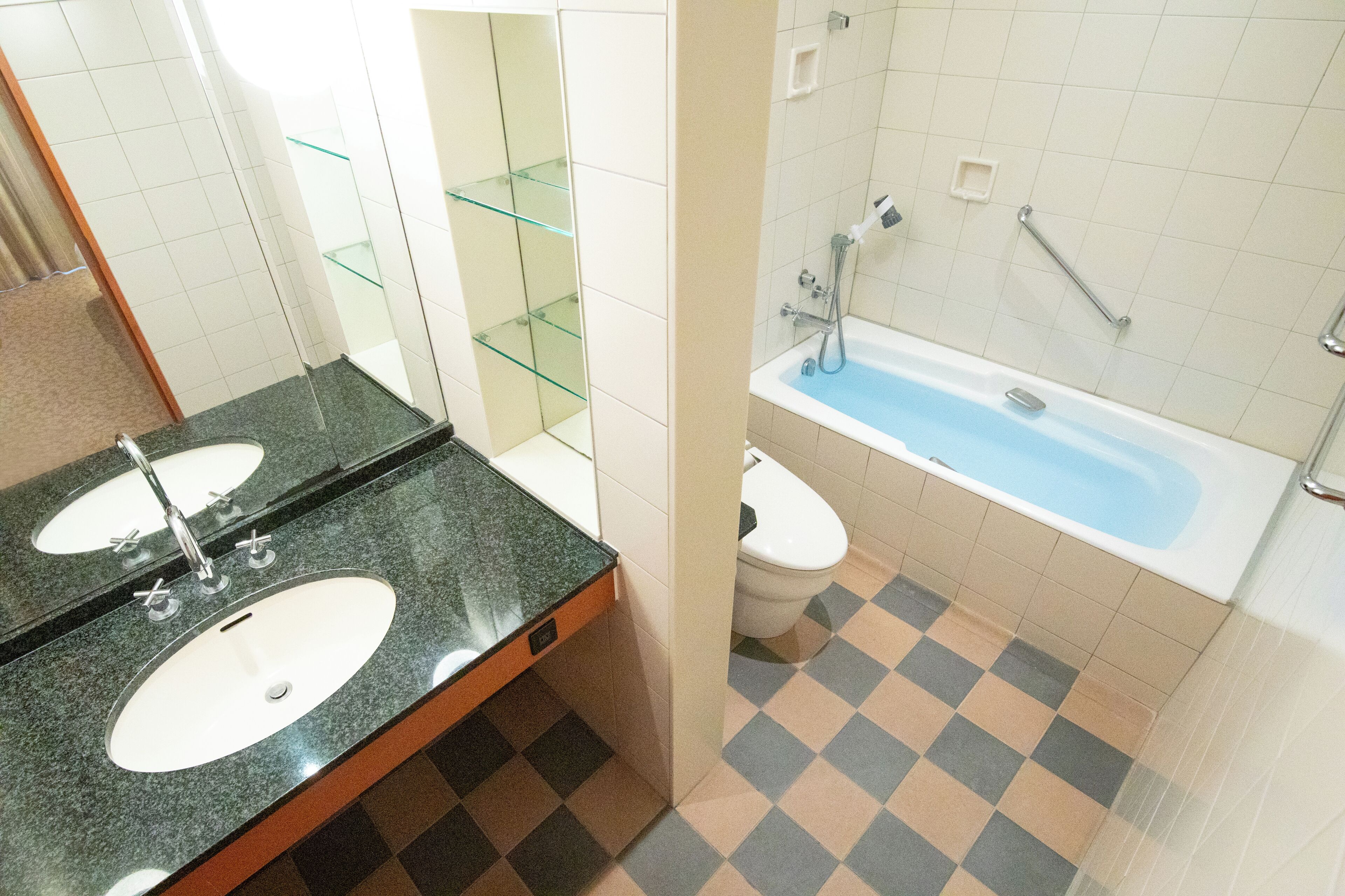 Un baño con dos lavamanos, un inodoro y una bañera.