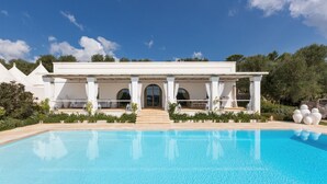 A modern villa with a swimming pool, a covered patio, and a view of the surrounding greenery. - Casa Murredda (Ostuni)