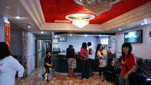 A lobby with a reception desk, a chandelier, and a clock on the wall. - Dajenshan Hotel (Hengchun)