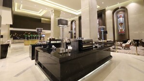 A modern lobby with a reception desk, seating area, and decorative elements. - Pullman Yangon Centrepoint (Yangon)