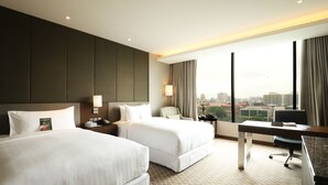 A hotel room with two beds, a desk, and a large window with a city view. - Pullman Yangon Centrepoint (Yangon)