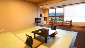 A room with tatami mats, a low table, chairs, a TV, and a window with a view. - Hotel Parens Onoya (Asakura)