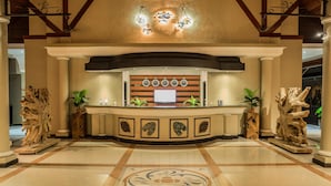Un área de recepción con un mostrador de madera, un reloj y un televisor.