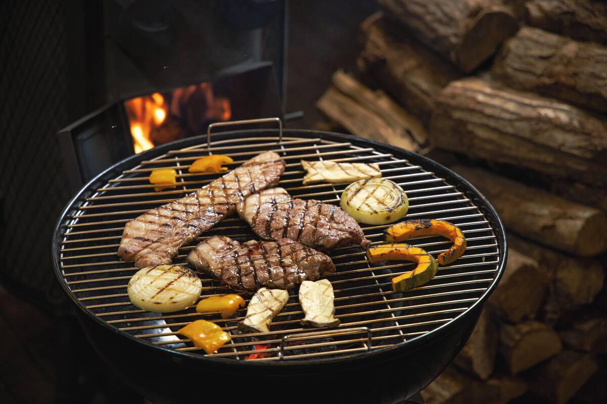Un barbecue avec des steaks et des légumes.