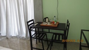 A dining area with a table, chairs, a tray with condiments, and a television mounted on the wall.