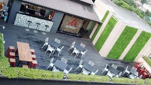 En restaurant med udendørs siddepladser, barområde og en grøn lodret have.