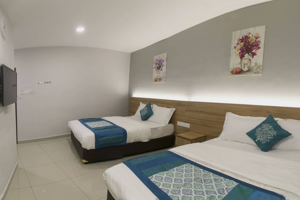Ein Hotelzimmer mit zwei Betten, einem hölzernen Kopfteil, einem wandmontierten Flachbildfernseher und zwei floralen Bildern.