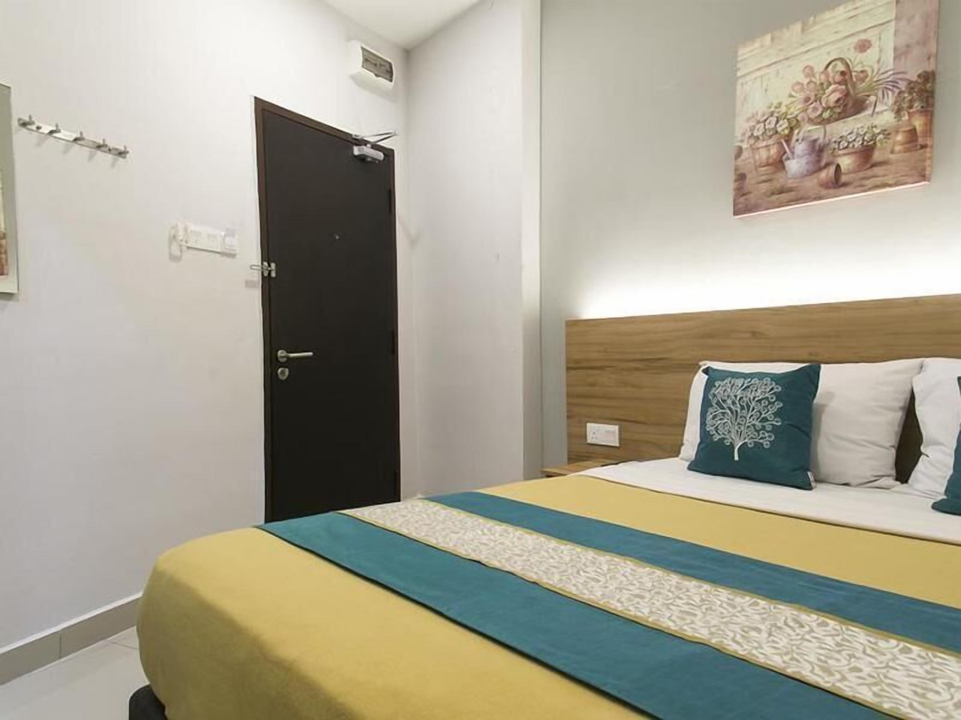 A bedroom with a bed, a wooden headboard, and a painting on the wall.
