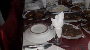 A dining table set with various dishes, plates, and utensils, indicating a meal setting. - Hotel Skylink (Dhaka)