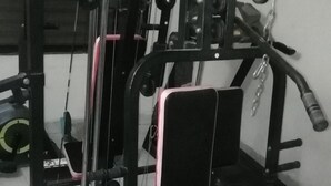 A gym with various exercise equipment including a squat rack, bench press, and weight machines. - Hotel Skylink (Dhaka)