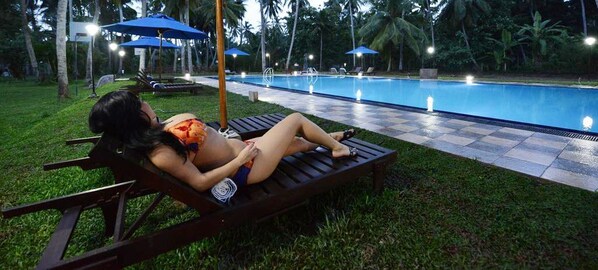 A woman relaxing on a lounge chair by a poolside. - Oreeka - Katunayake Airport Transit Hotels (Negombo)