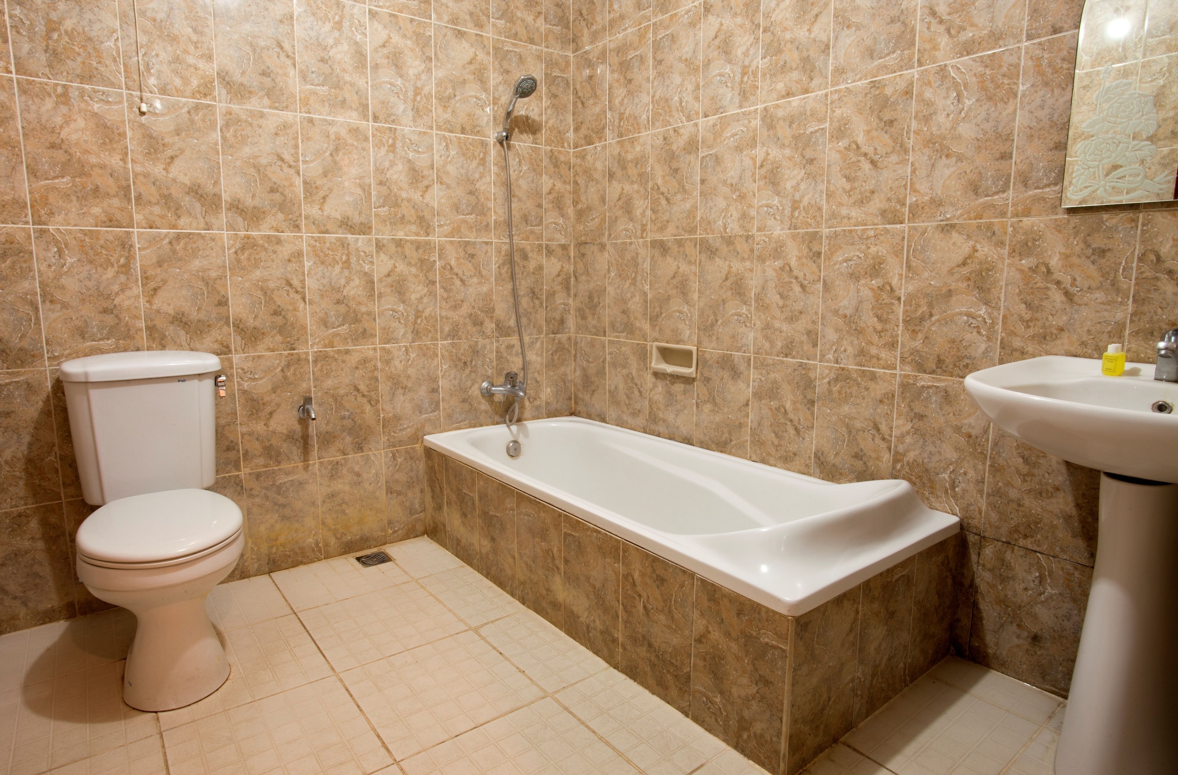 Een badkamer met toilet, bad en wastafel.