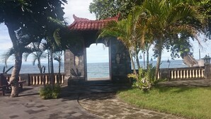 A gazebo with a tiled roof overlooking a beach. - Batu Bolong Cottages (Senggigi)