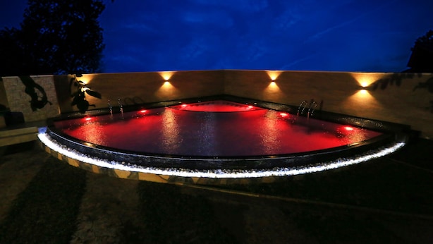 A circular pool with a red-lit edge, surrounded by a low wall with small lights. - Villa Thotiya (Aluthgama)
