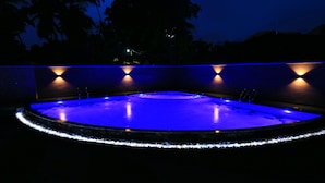 A swimming pool with a blue-lit edge and wall-mounted lights. - Villa Thotiya (Aluthgama)