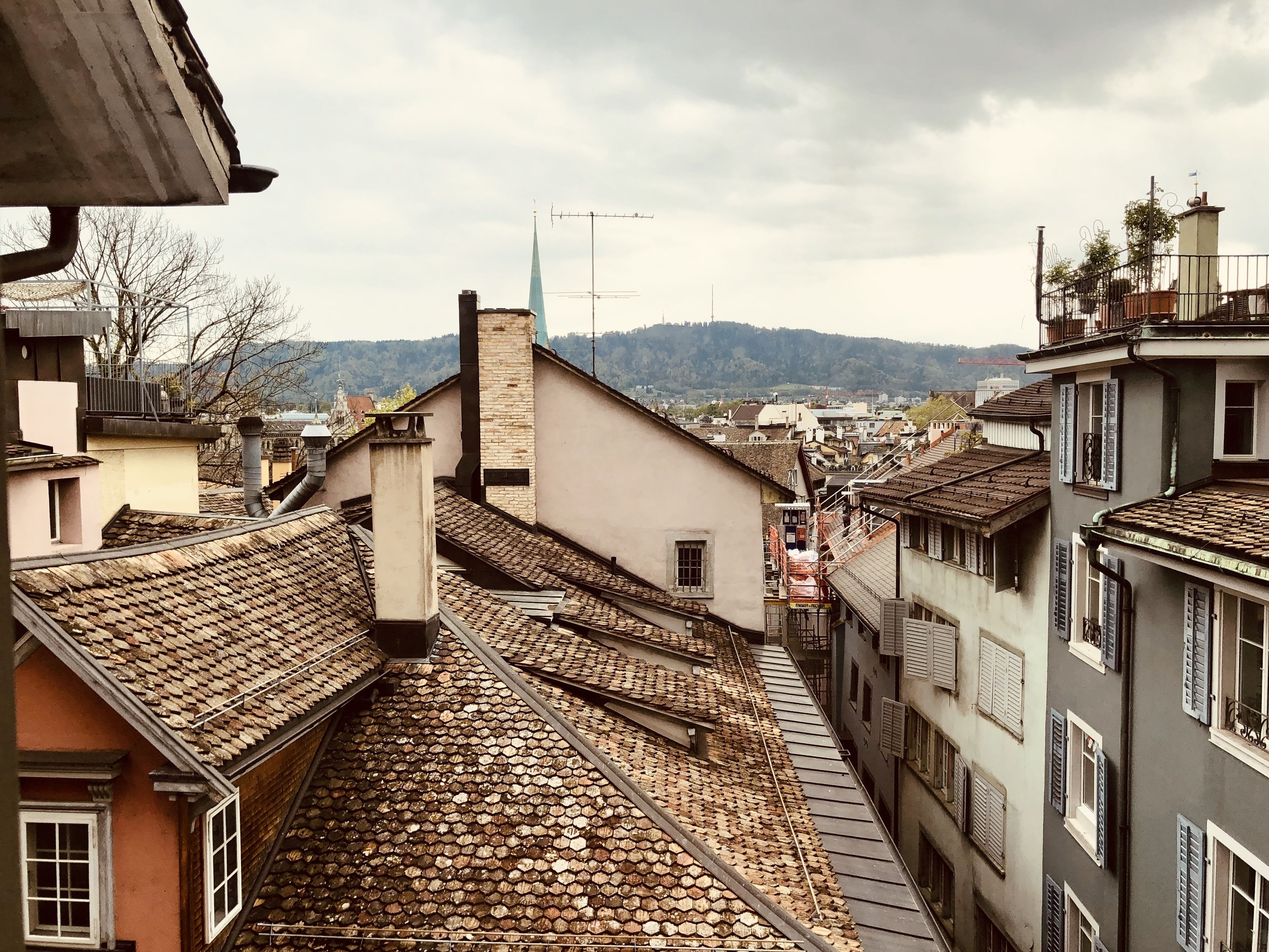 Una calle estrecha con edificios tradicionales, techos empinados y una vista distante de la montaña.