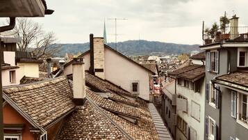 Una calle estrecha con edificios tradicionales, techos empinados y una vista distante de la montaña.
