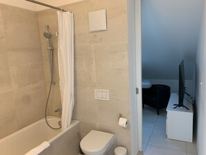 Ein modernes Badezimmer mit Dusche, Toilette und einem kleinen Waschbecken.