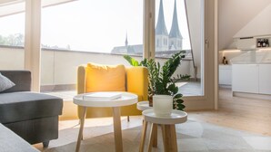 A modern living room with a sofa, a yellow armchair, a small table, and a potted plant. - Top city center Lion Monument (Lucerne)