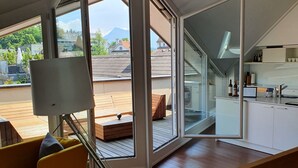 A modern living space with a wooden deck, a sofa, and a kitchen area. - Top city center Lion Monument (Lucerne)