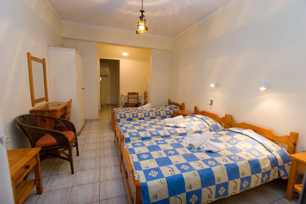 Ein Schlafzimmer mit zwei Betten, einem Schreibtisch und einem Stuhl.