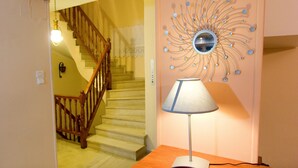 Una scala con ringhiere in legno e una lampada a parete con uno specchio.