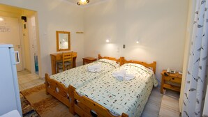 Una camera da letto con due letti in legno, una scrivania di legno, uno specchio e un comodino.