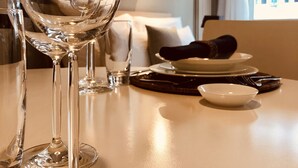Una mesa de comedor con una copa de vino, un bol y un plato listos para una comida.