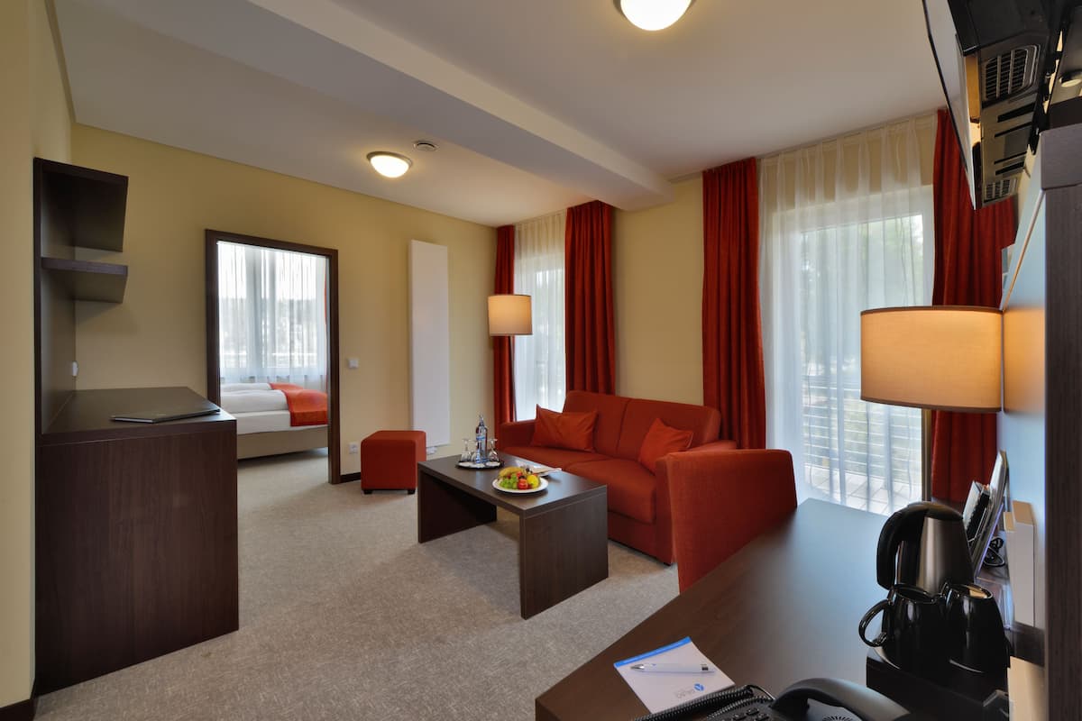 Une chambre d’hôtel équipée d’un bureau, d’un canapé, d’une table basse et d’un lit.