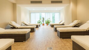 A spa room with four reclining chairs, a tiled floor, large windows, and potted plants. - ARIBO Hotel Erbendorf (Erbendorf)