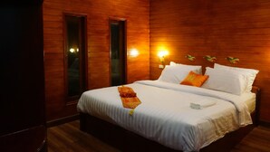 A wooden-paneled bedroom with a bed, pillows, and a nightstand. - Ruenthai Boutique (Sa Khu)