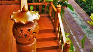 Una escalera de madera con barandillas ornamentadas y una urna decorativa en la parte superior.