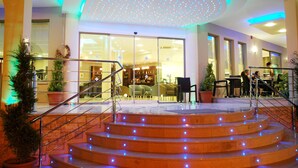 A hotel lobby with a staircase, seating area, and a bar. - Letsos Hotel (Zakynthos)
