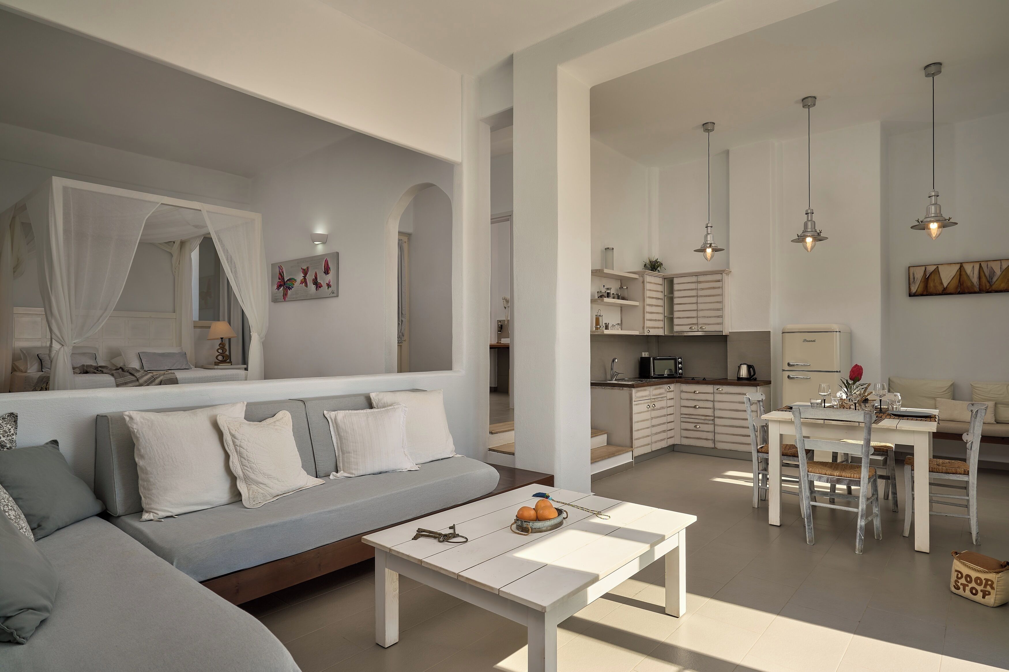 A modern living room with a sofa, dining table, and kitchen area.