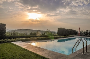 Outdoor pool, an infinity pool, pool umbrellas, pool loungers