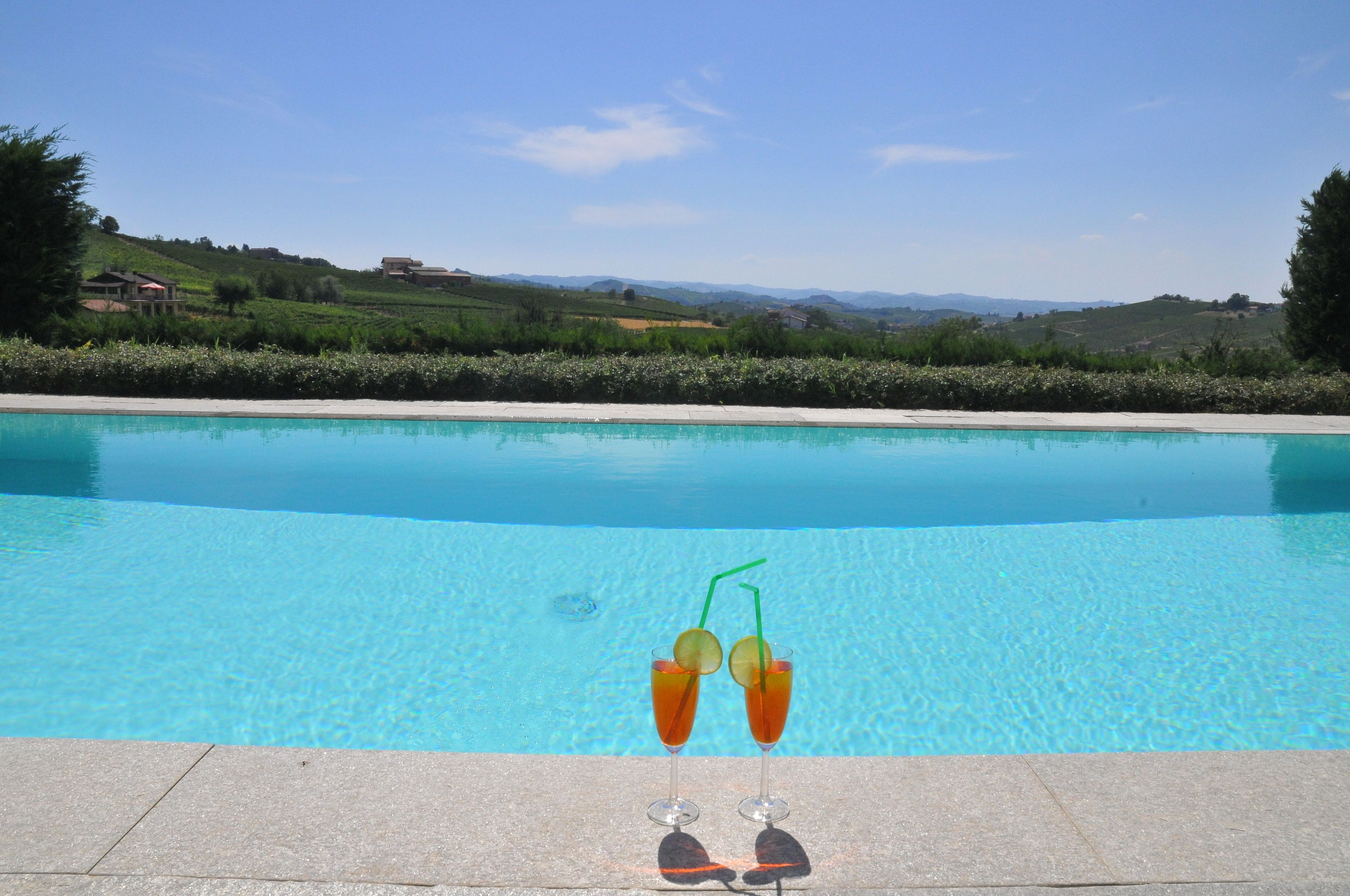 Utomhuspool, infinity-bassäng, parasoller och solstolar