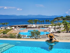 Área da piscina com vista para o oceano e montanhas.