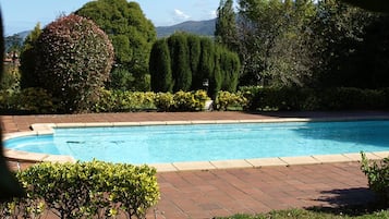 Una piscina al aire libre de temporada, sillones reclinables de piscina