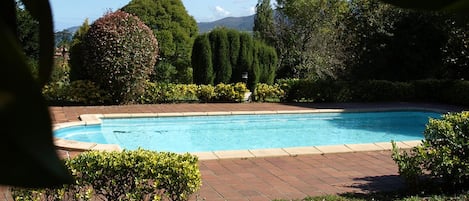 Una piscina al aire libre de temporada, sillones reclinables de piscina