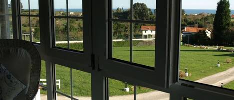 A room with large windows offering a view of a green landscape and a road.