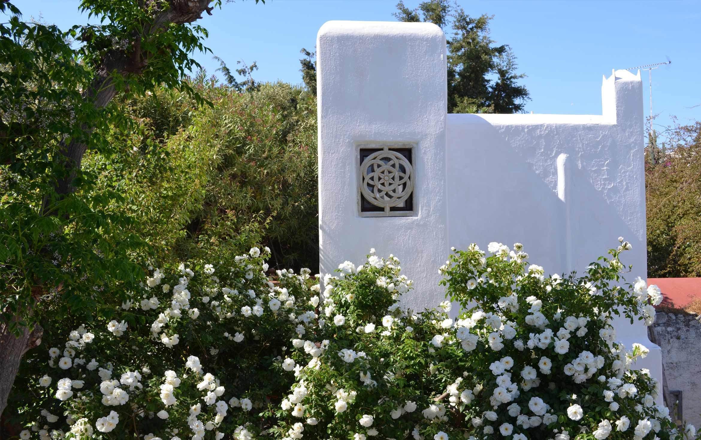 A white building with a decorative window and a small balcony.