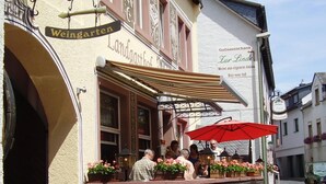 A building with a sign reading "Weingarten" and "Landgasthof Zur Lindel". There is a blue parking sign with an arrow pointing left. - Landgasthof Germania (Ruedesheim am Rhein)
