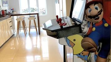 Eine moderne Küche mit integriertem Laptopständer, Holzstühlen und einem großen Fenster, das für natürliches Licht sorgt.