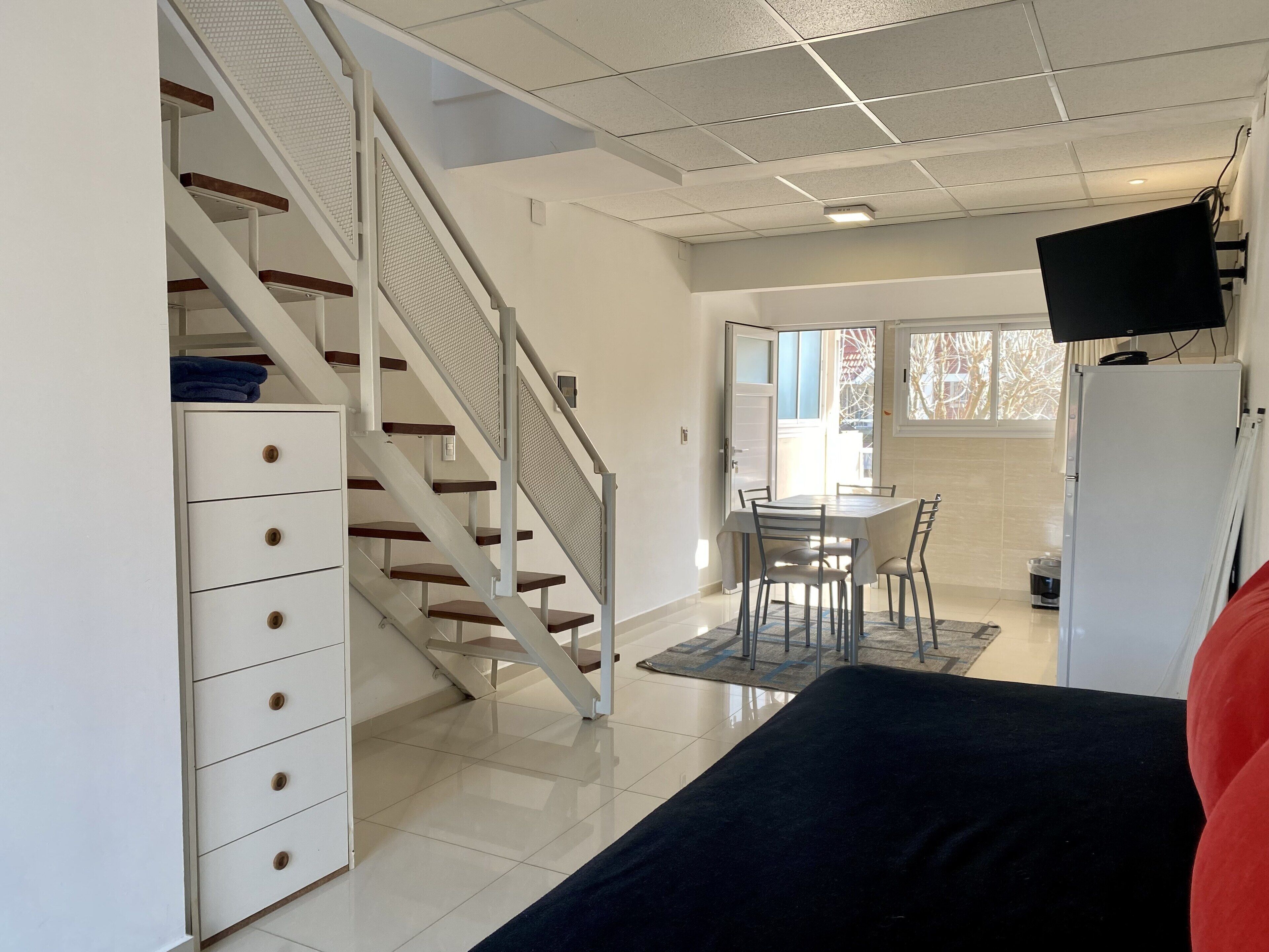Um interior moderno com uma escada, uma sala de jantar e uma sala de estar.