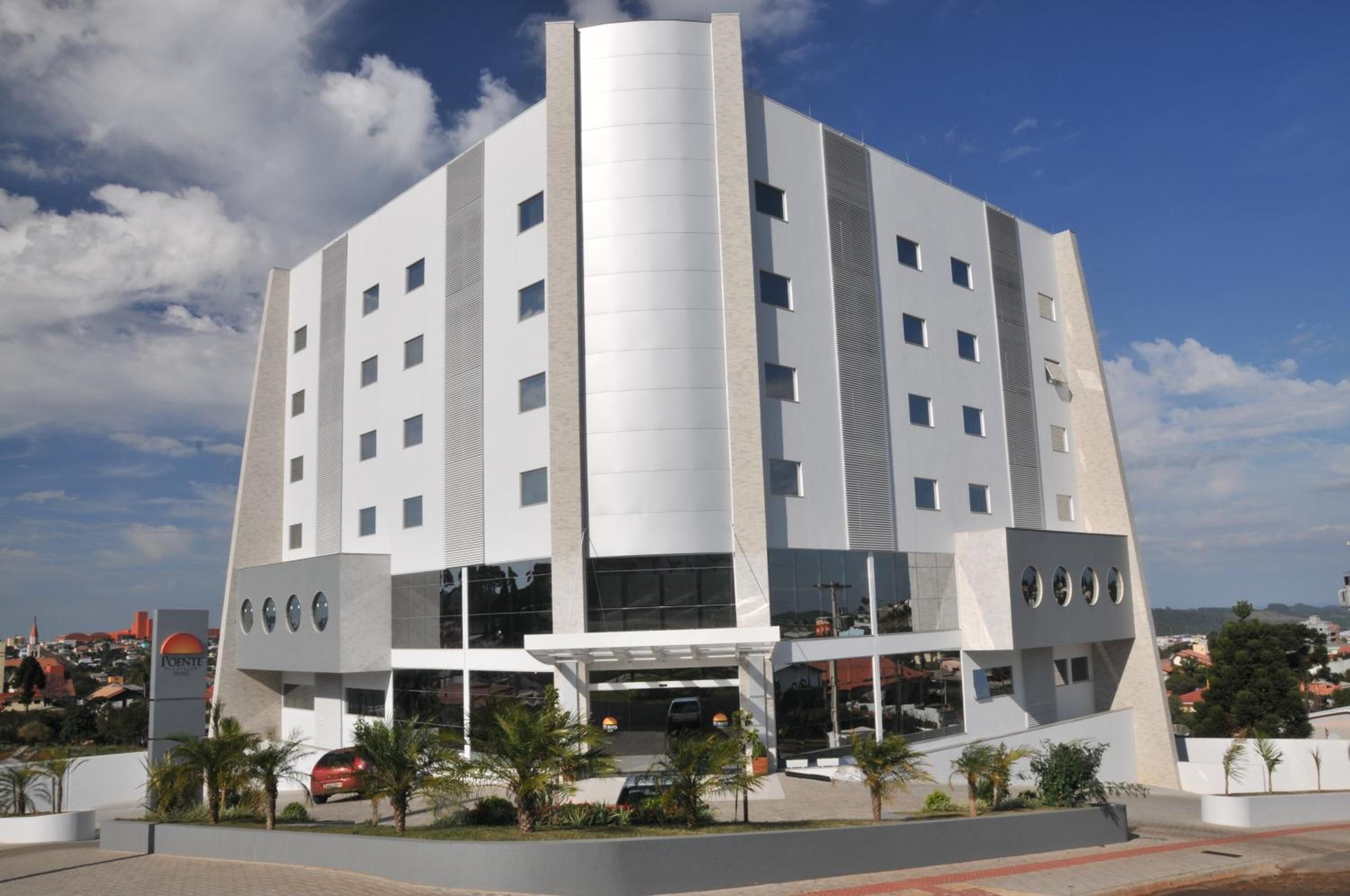 A modern building with a central vertical feature, multiple windows, and a covered entrance area.