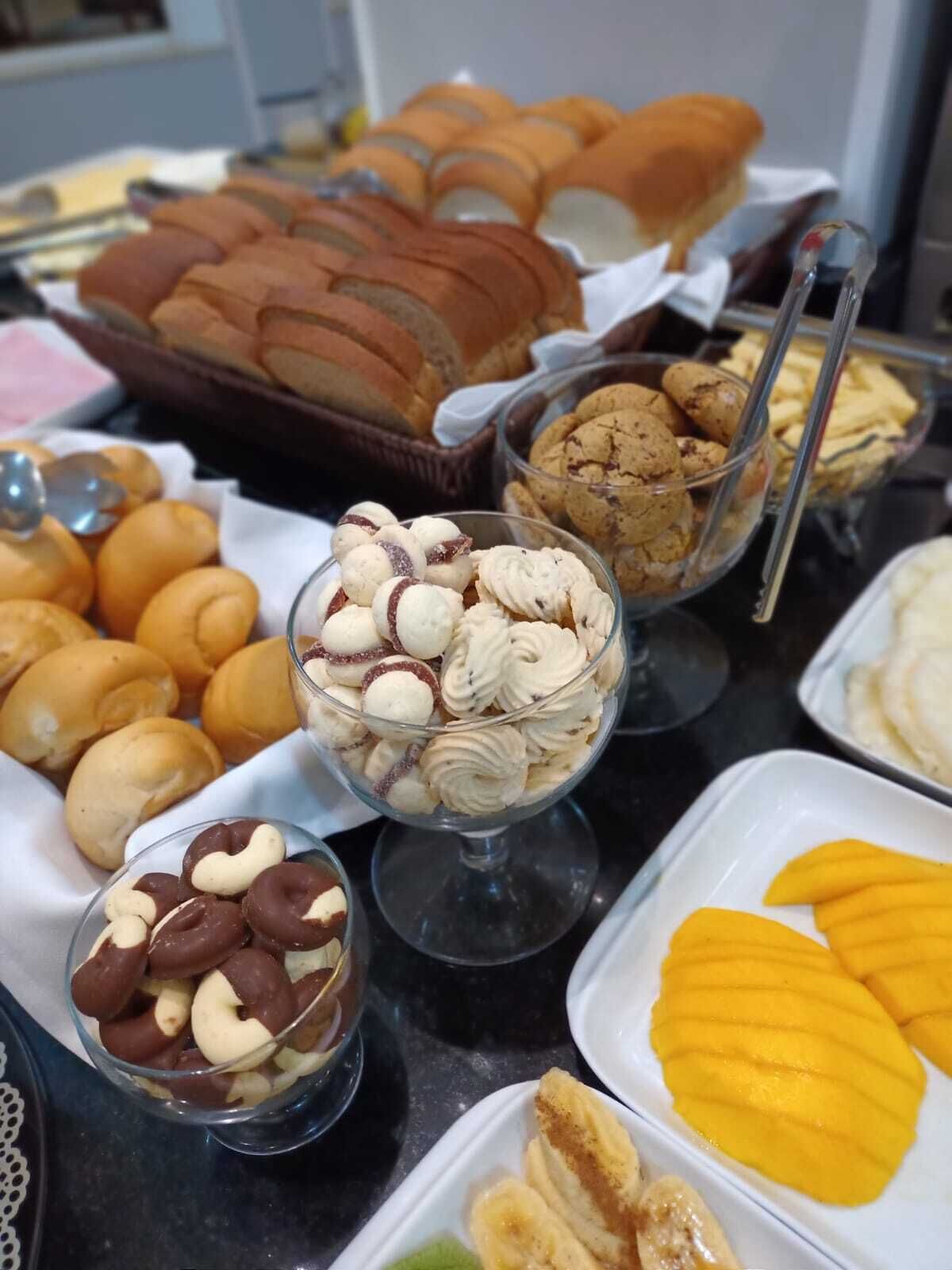 A buffet table with various food items including pastries, cookies, and fruit slices.
