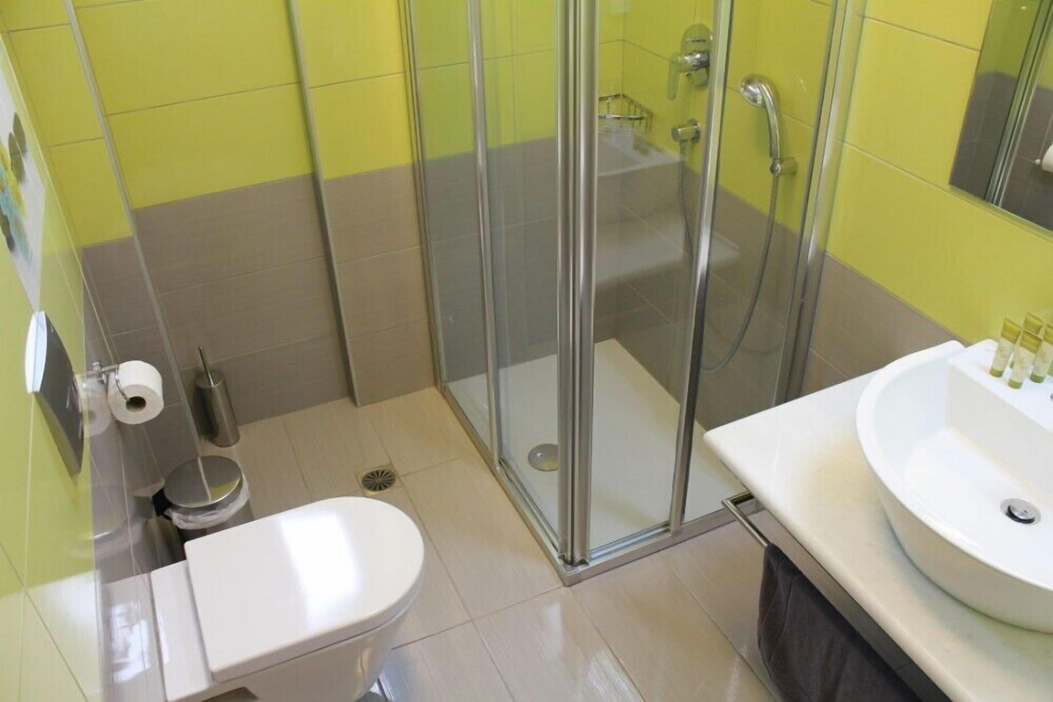 A bathroom with a toilet, a sink, and a glass-enclosed shower area.