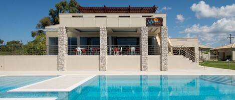 Piscina a l'aire lliure de temporada, para-sols i gandules